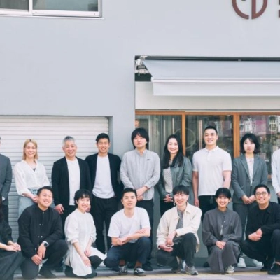 Group photo of a team posing outside a modern building.