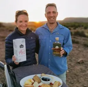 Two founders of IBHU Distillery proudly presenting their spirits in the South African outdoors.
