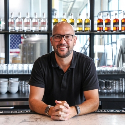 Manifest Gin distillery founder at the bar of his craft gin distillery in the USA — premium American craft gin producer