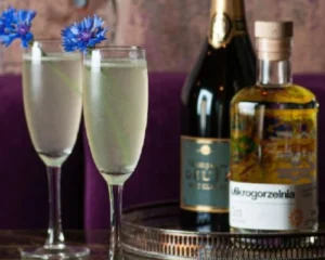 French 75 cocktail served in champagne flutes with gin, sparkling wine and blue cornflower garnish