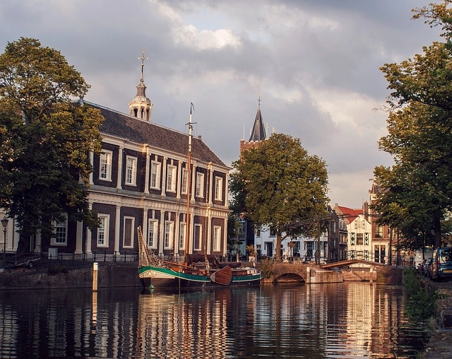 Canal view of Schiedam with historic buildings and a traditional boat, birthplace of jenever