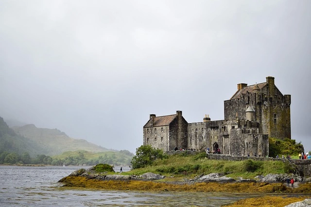 Historic Eilean Donan Castle on a misty shoreline in Scotland
