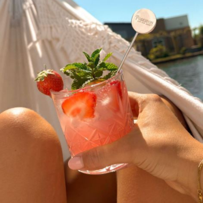 Poseidon Dry Gin cocktail with blood orange soda, strawberries, mint and ice in a crystal glass.