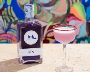 Purple Rain gin cocktail made with INK Dry Gin, served in a coupe glass with a pink colour and sugared rim