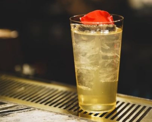 Whispering Luna, a Gin and tonic cocktail with floral garnish prepared at the bar