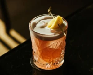 Exceptional Gin Martinez cocktail in crystal Old Fashioned glass with lemon zest garnish — a classic craft gin cocktail made with premium Portuguese gin
